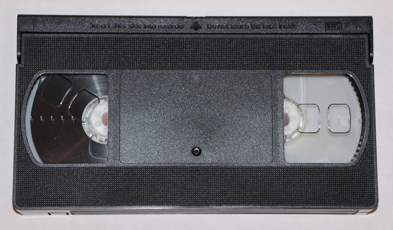 Czarna kaseta VHS z widocznymi szpulami taśmy